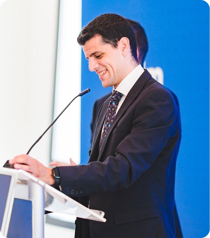 Beppe speaking at a podium